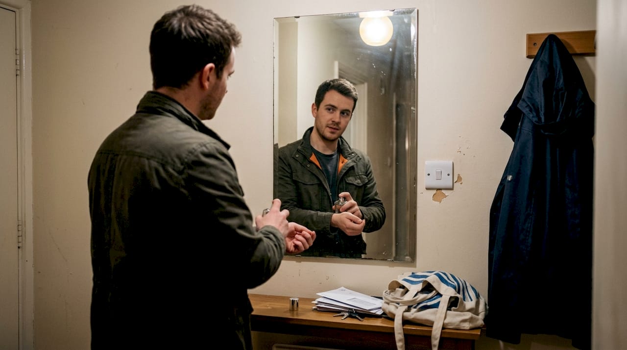 Man applying cologne in hallway mirror setting