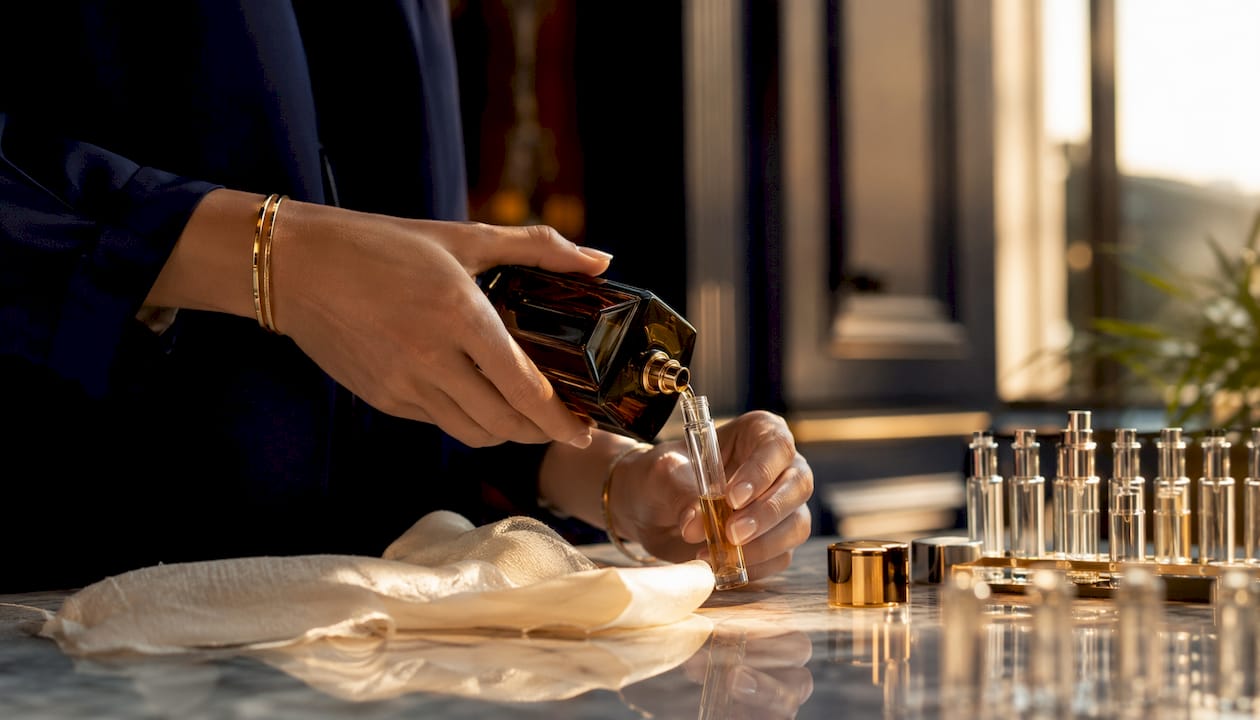 Close-up of pouring luxury perfume into decant vial