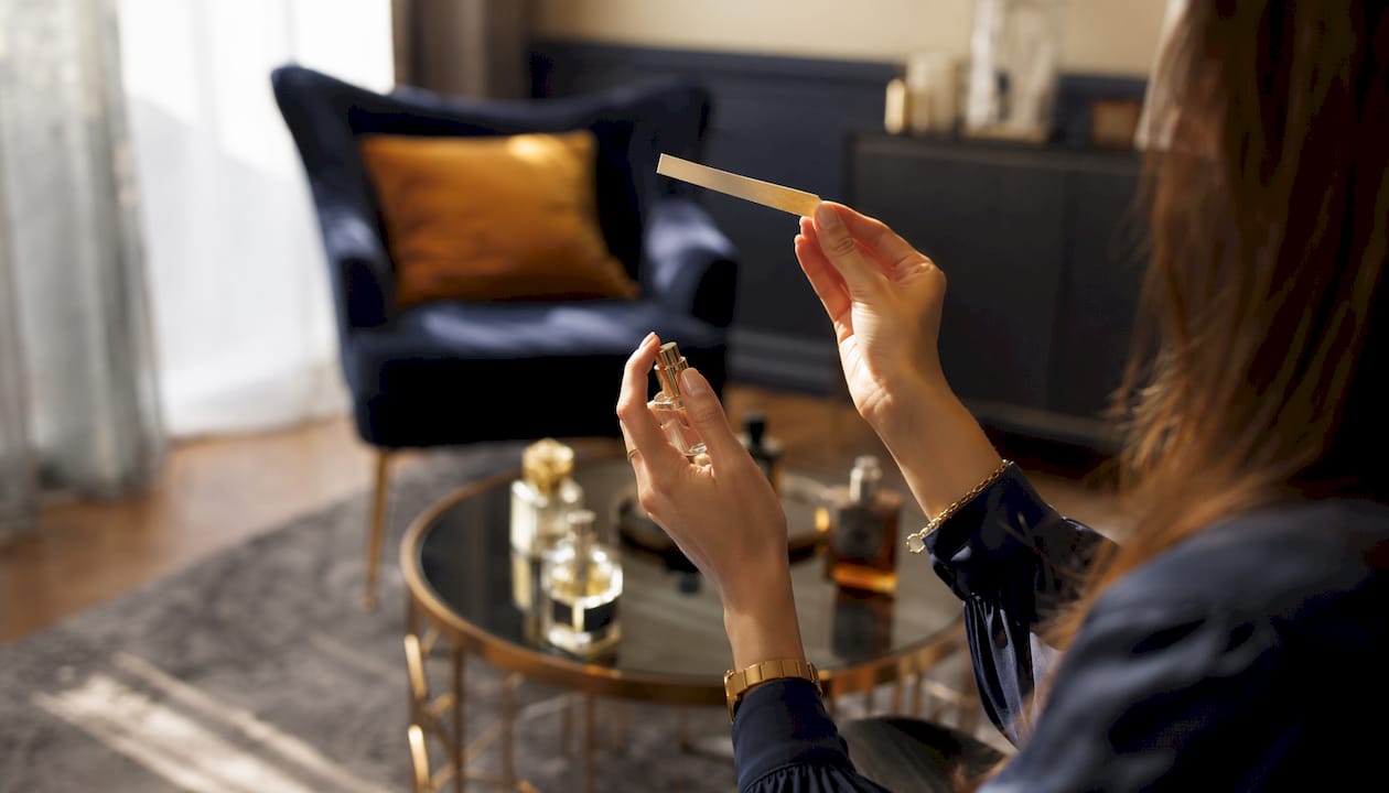 Hands holding fragrance blotter for testing