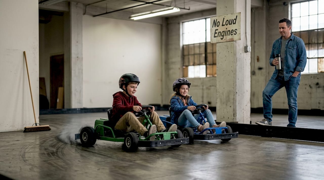 Siblings ride electric go-karts indoors quietly