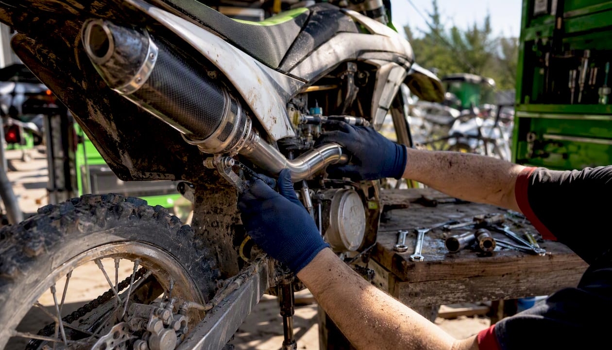 Hands inspecting modified motorcycle exhaust