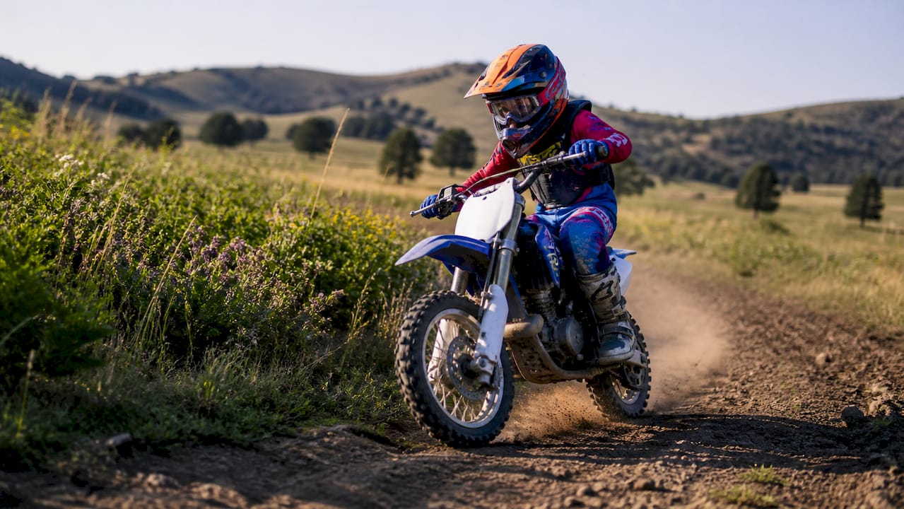 Youth on off-highway motorcycle on trail