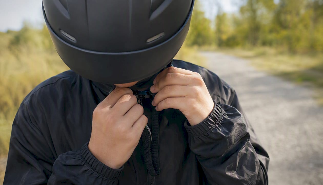 Youth adjusting helmet strap outdoors