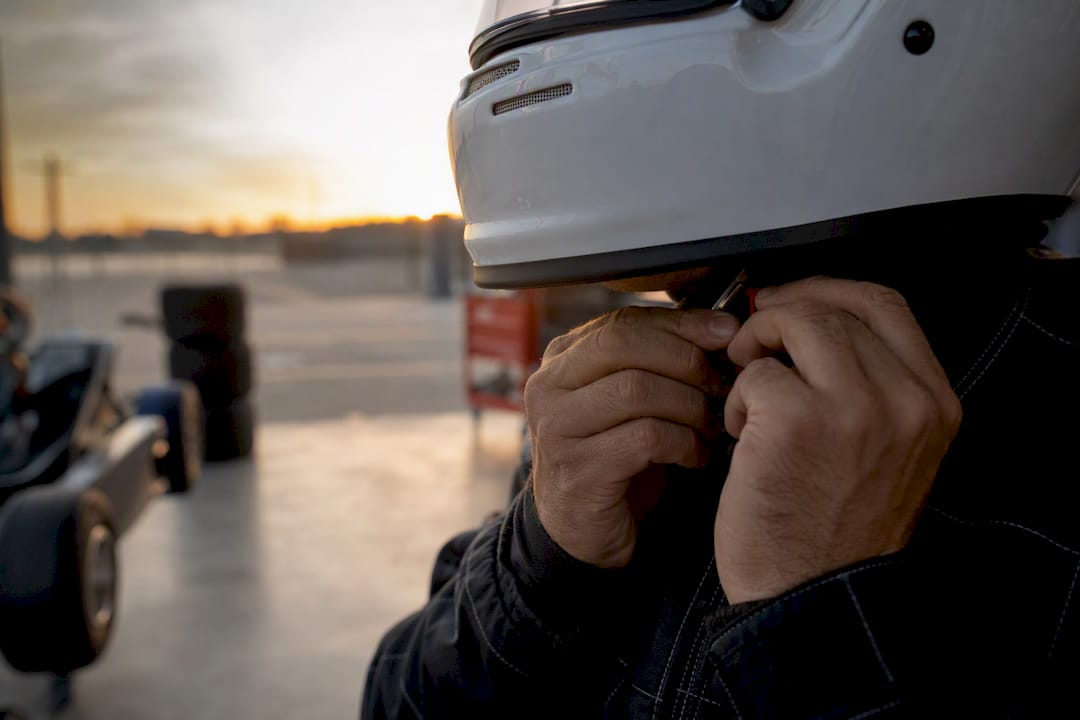 Hands tightening racer helmet chin strap
