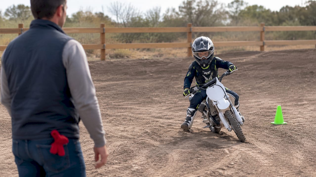 Parent supervising child dirt bike test