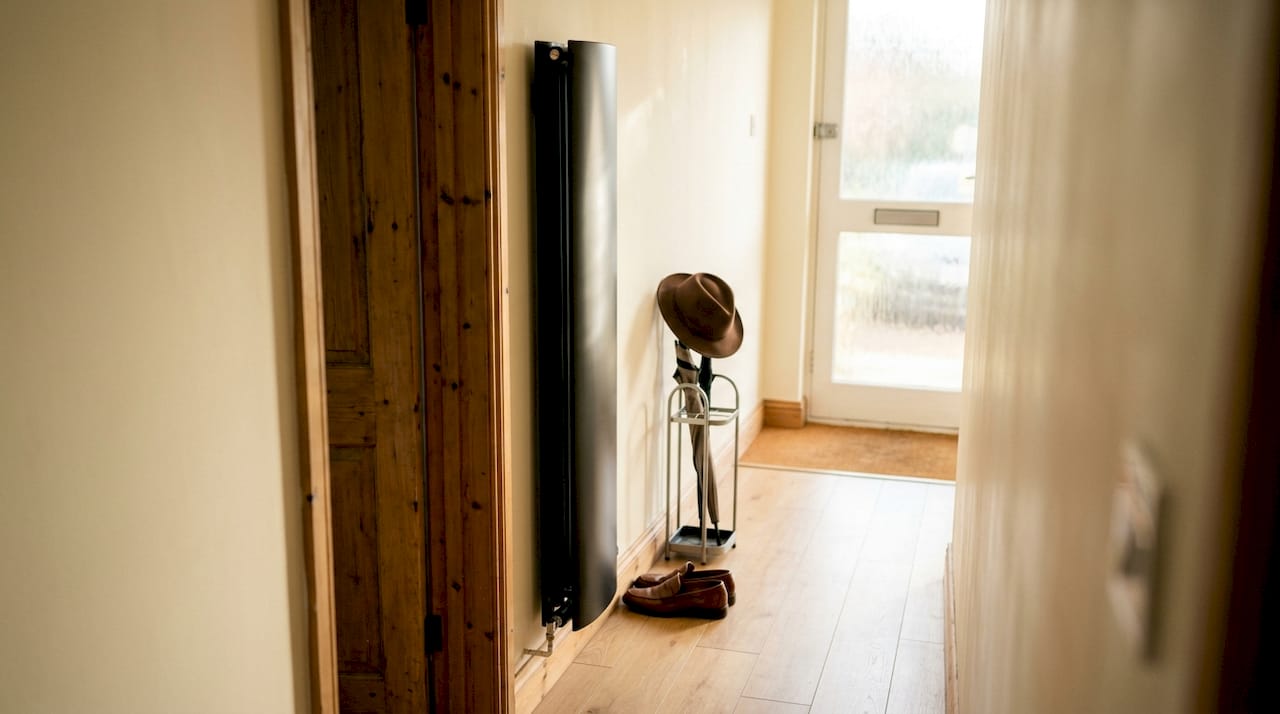 Matte black vertical designer radiator in hallway