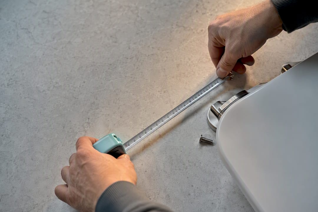 Hands measuring soft close seat hinge spacing