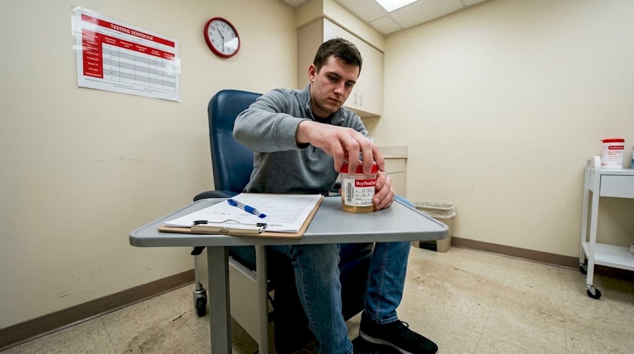 Patient holding urine sample in rehab clinic