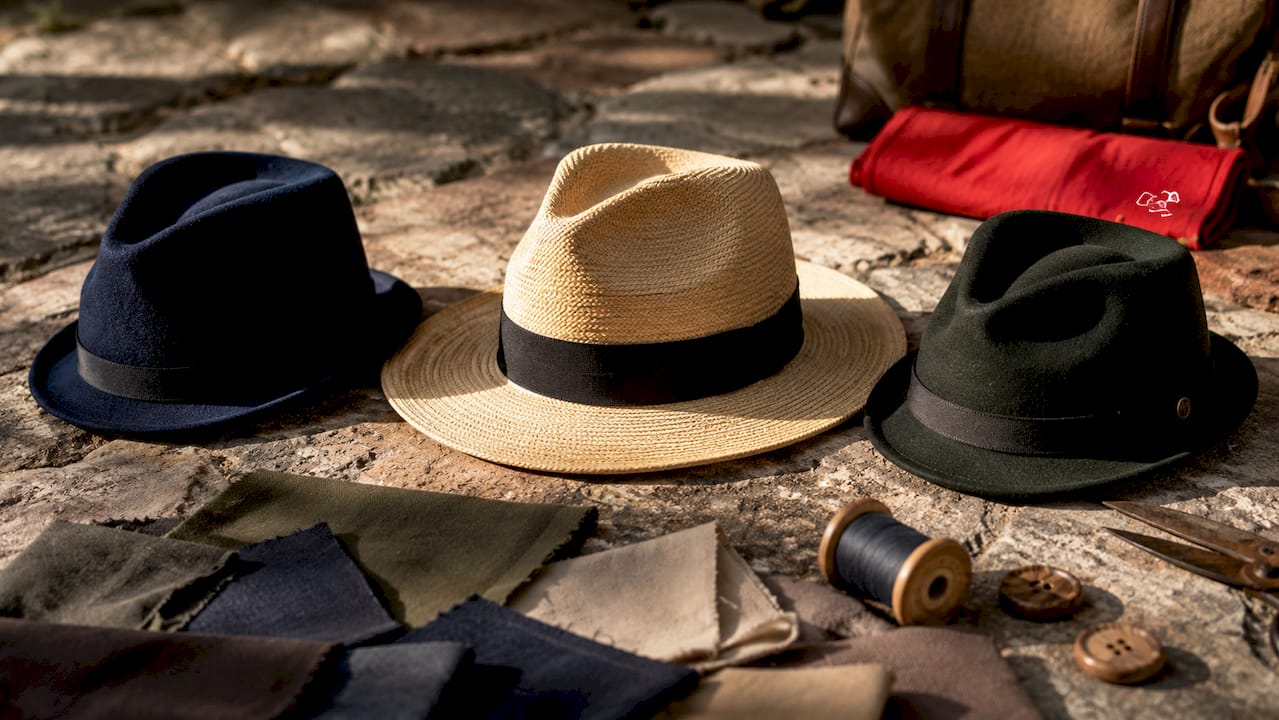 Three different fedora hats arranged on table