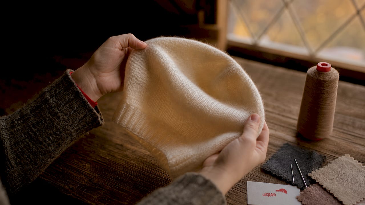 Close-up of hands showing merino wool hat texture