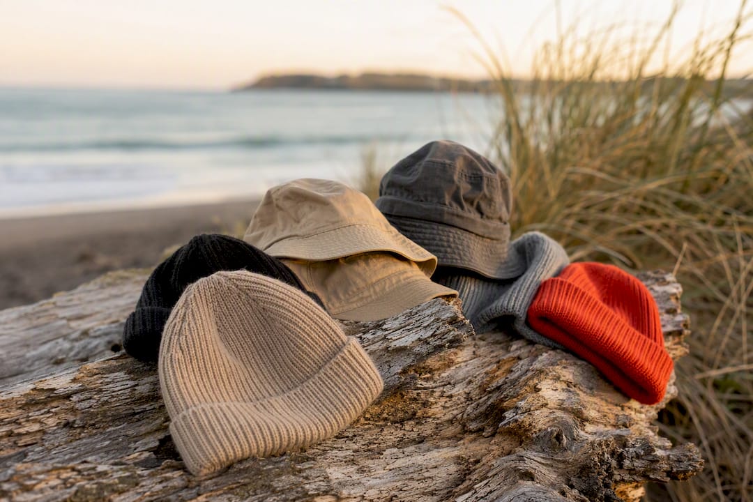 Wool beanies and bucket hats on driftwood