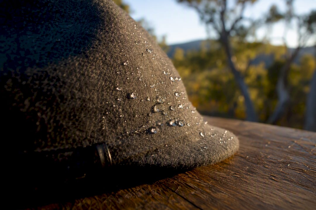 Water droplets beading on treated wool hat surface