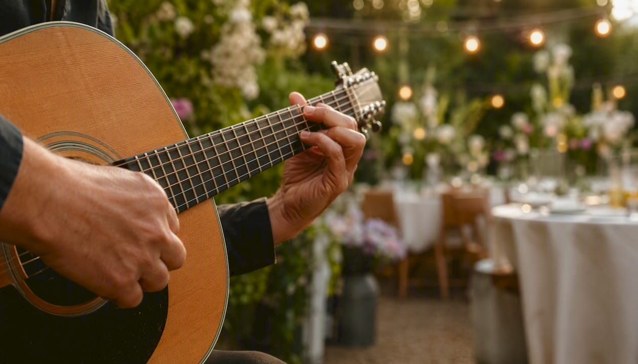 Hænder, der spiller akustisk guitar til en elegant middag