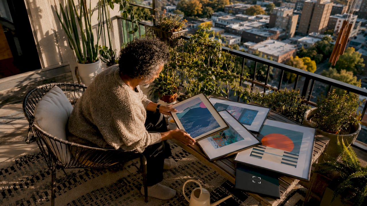 Person selecting artwork in warm lit living room