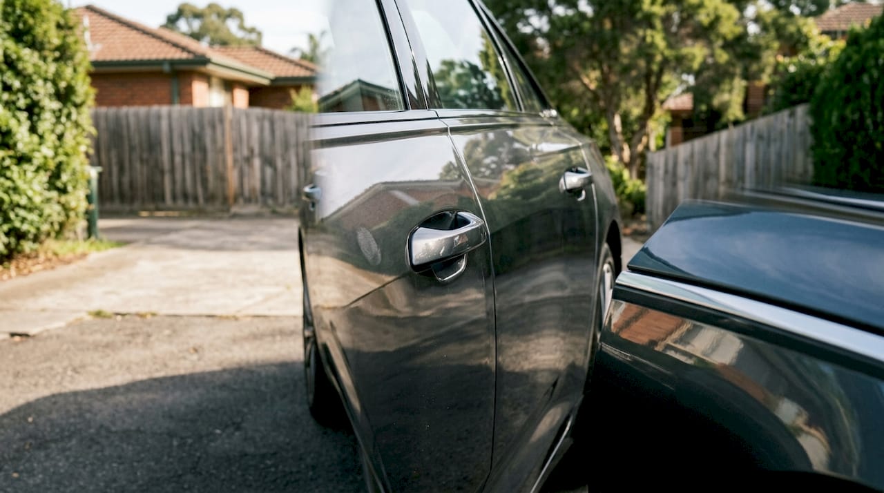 High-gloss car panel reflecting surroundings