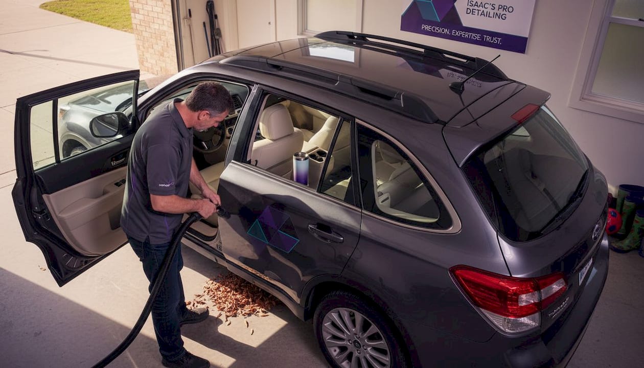 Man detailing family SUV interior in home garage