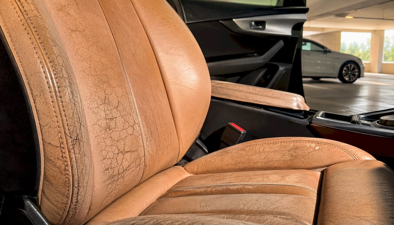 Close-up damaged faded leather car seat