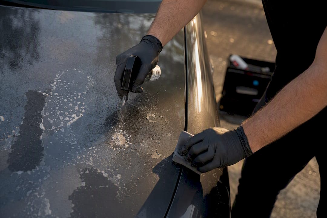 Hands cleaning aged paint protection film residue