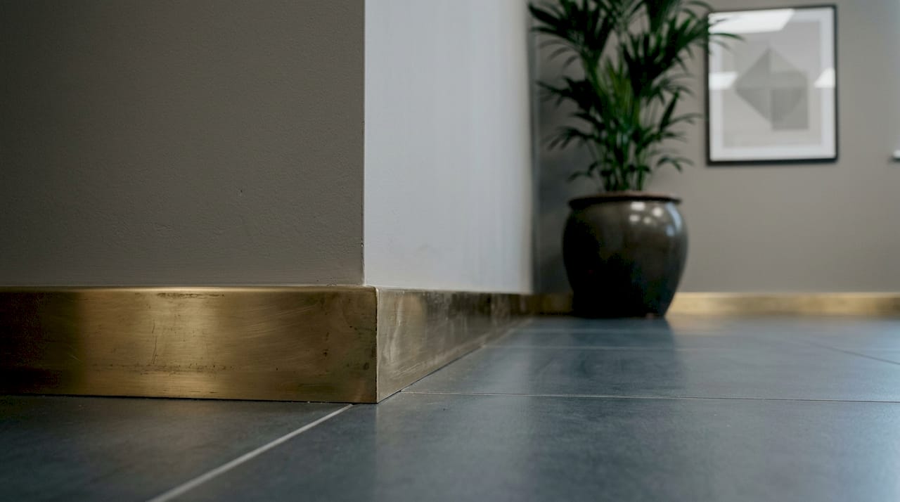 Close-up of brass trims connecting floor and wall