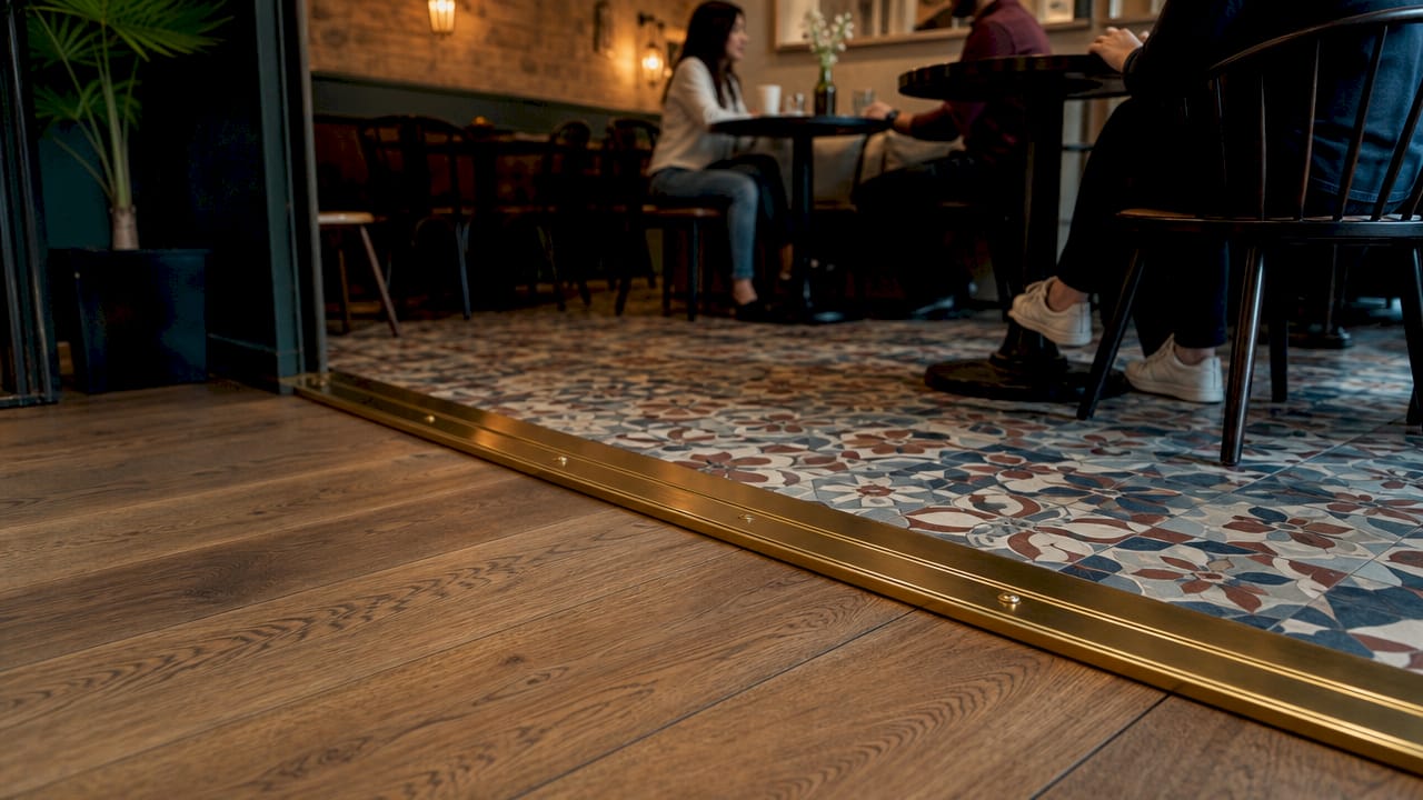 Close-up of durable solid brass door bar on flooring transition