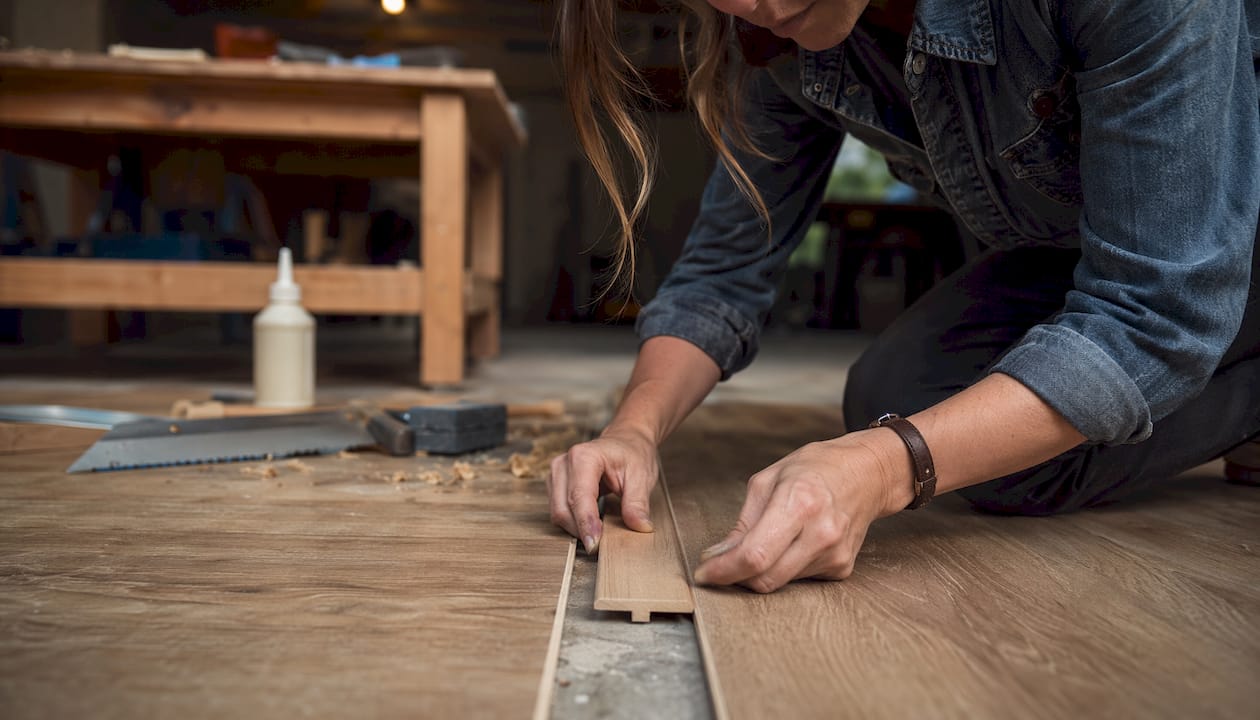 Close-up of hands fitting wooden T-moulding profile