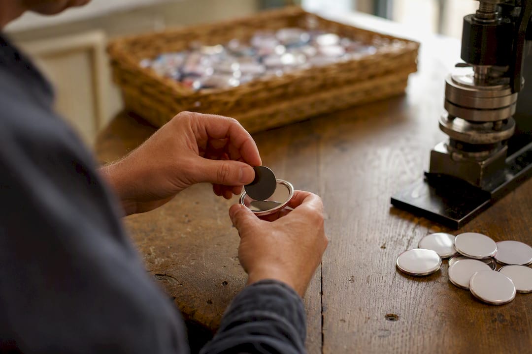 Hands fitting magnet backing to button badge