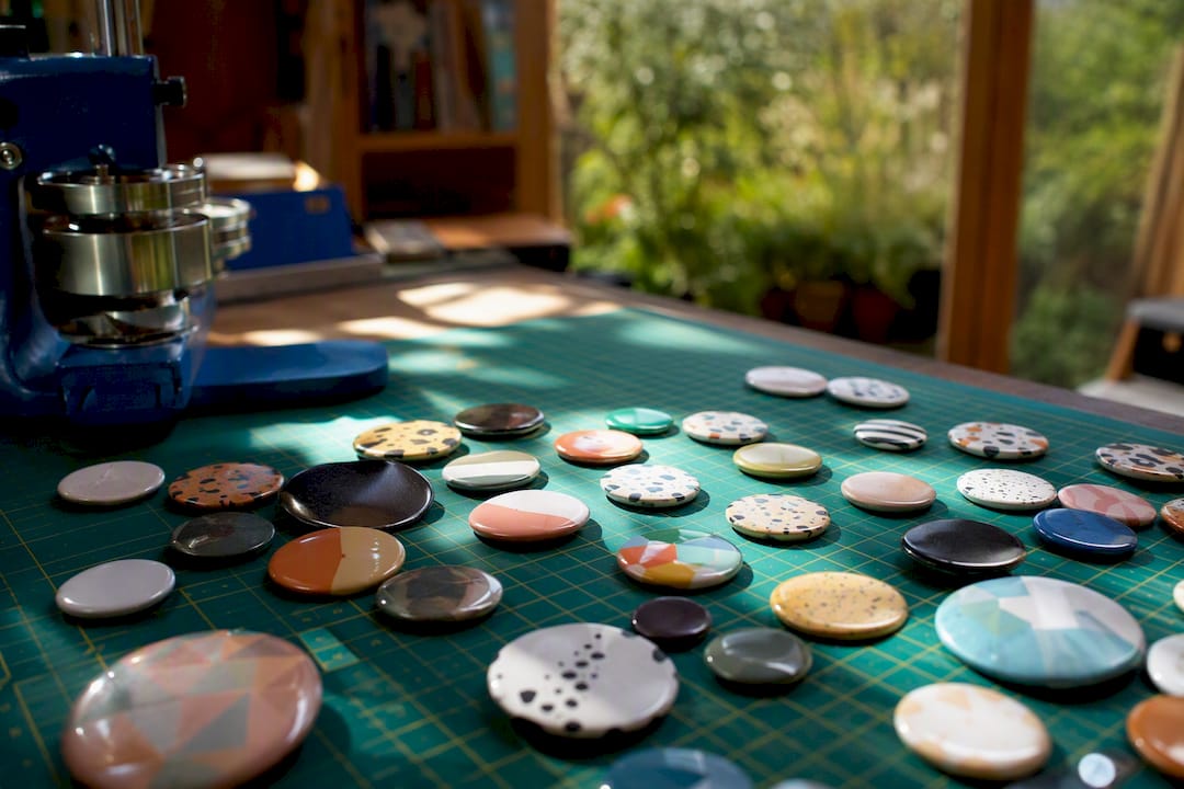 Mixed pack of small and standard button badges on fabric