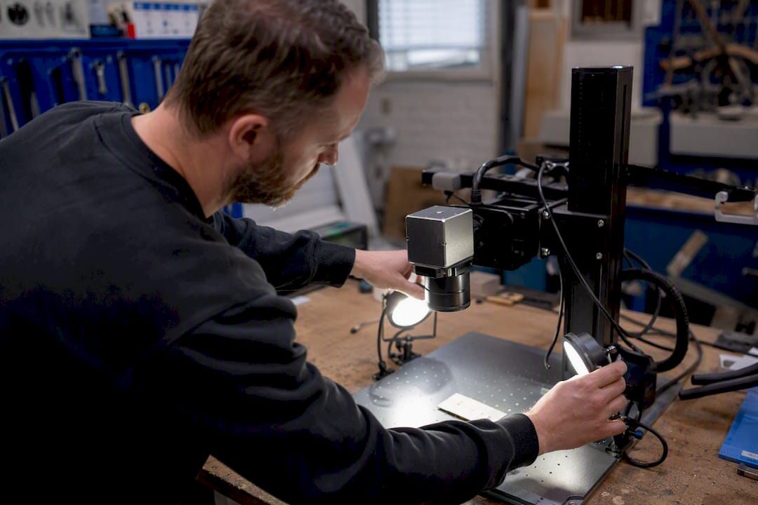 Hands adjusting LED lighting for laser camera