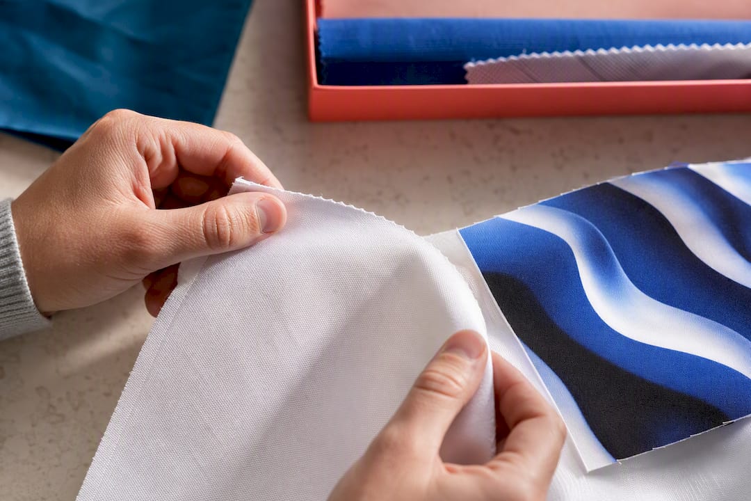 Hands inspecting a sublimation fabric sample