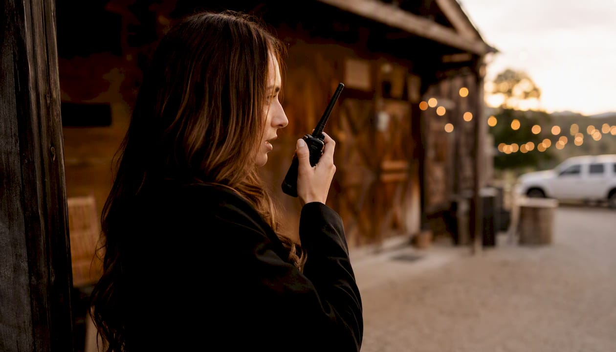 Venue coordinator speaking into walkie-talkie outdoors