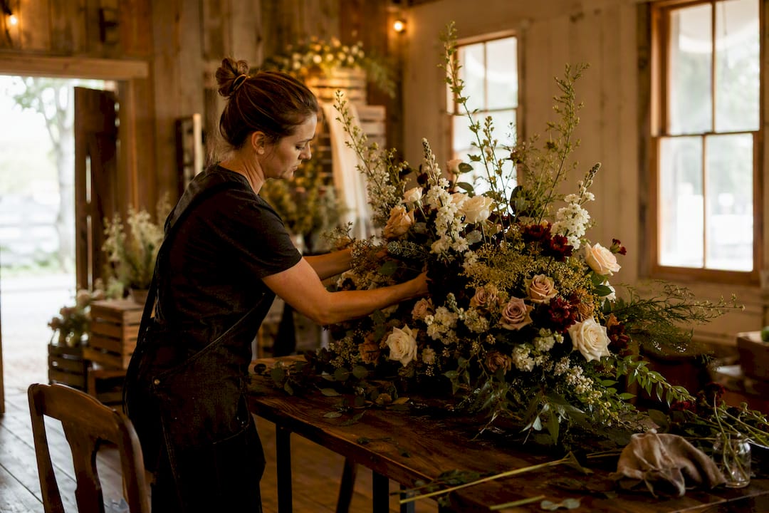 Florist arranging floral centerpiece indoors