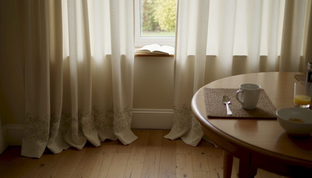 Interlined curtains drape by bay window in dining room