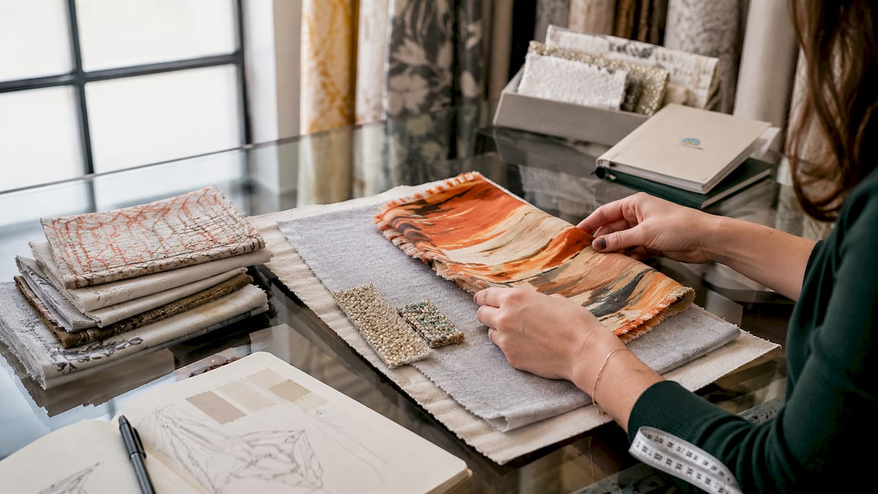Hands layering textile samples showing 60-30-10 rule