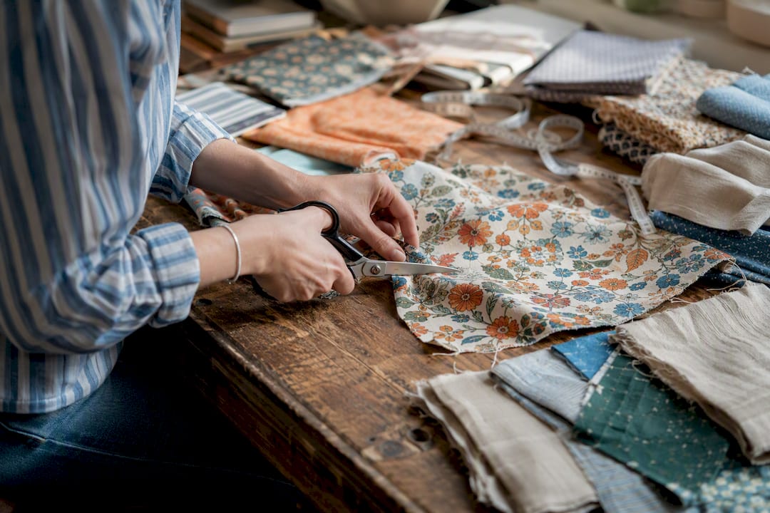 Hands cutting fabric remnants for cushions