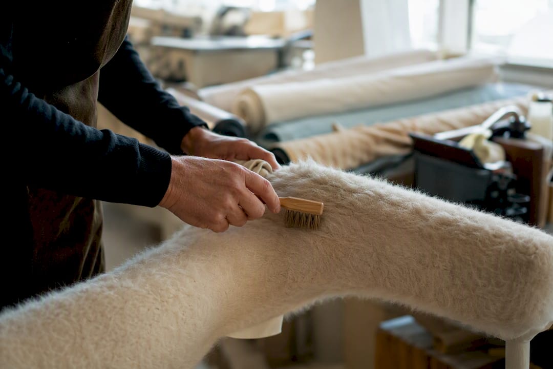 Hands spot-cleaning mohair upholstery fabric