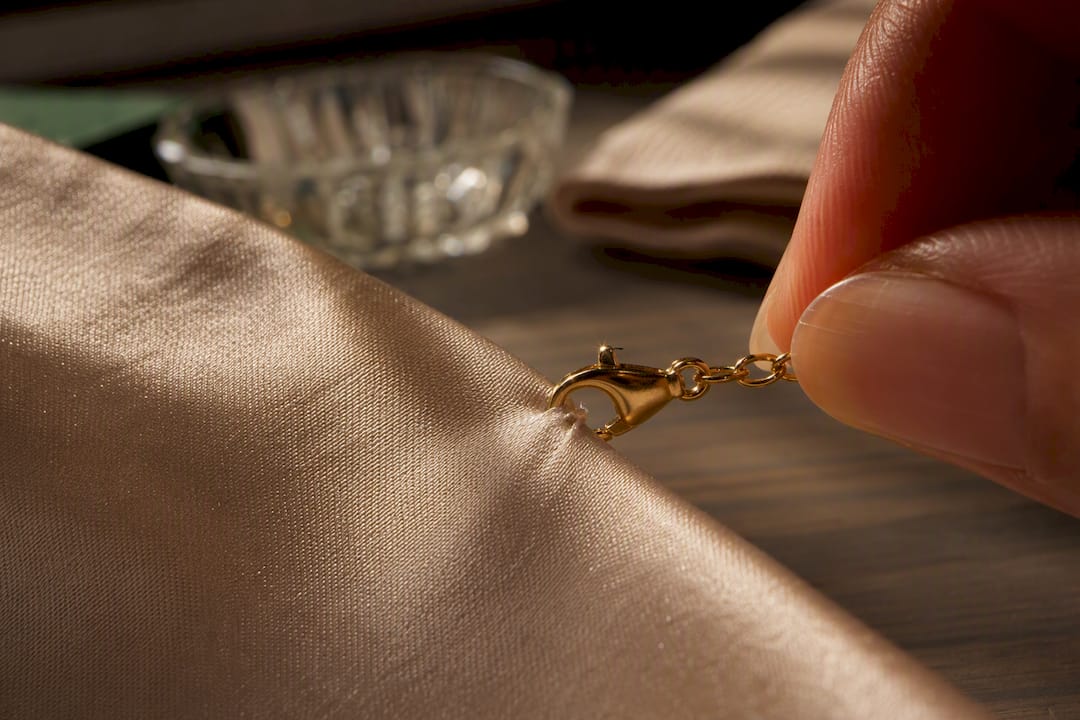 Jewelry clasp catching delicate satin fabric