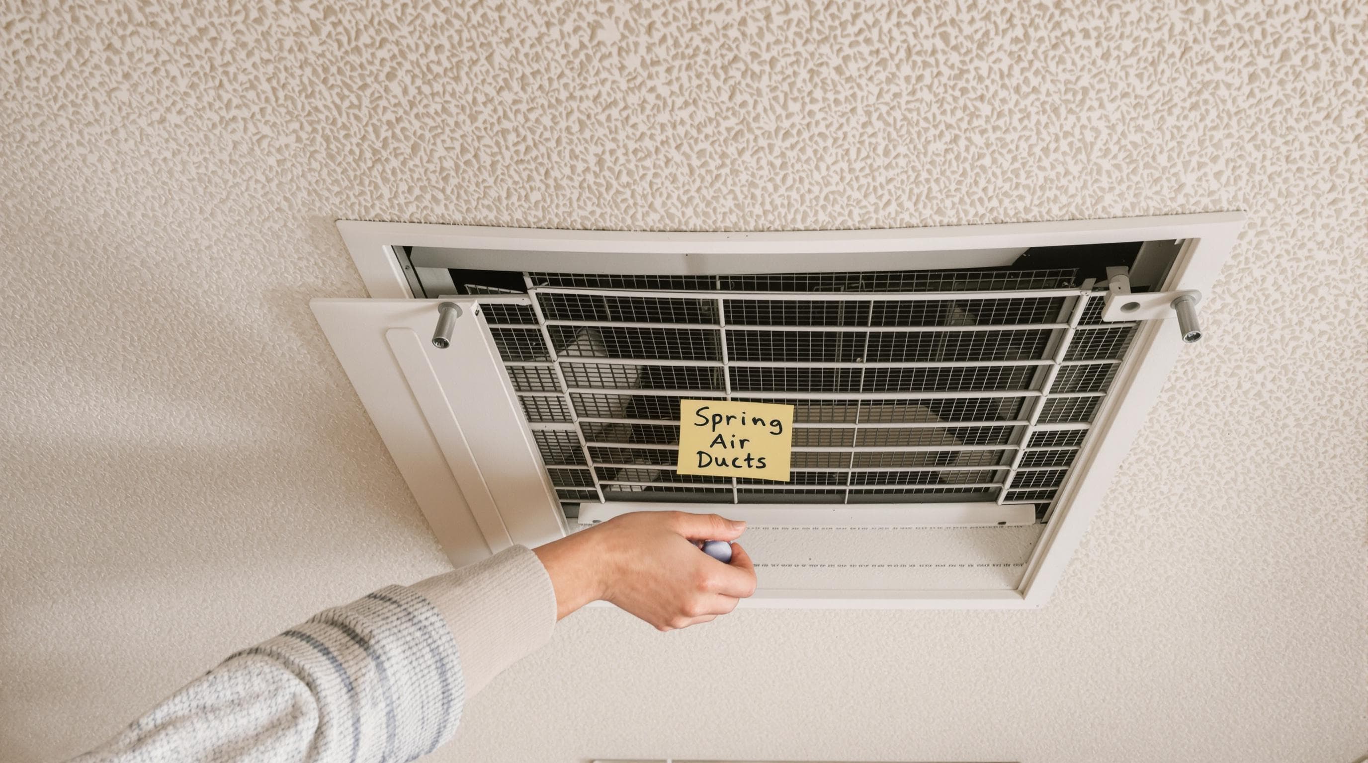 Texas family cleaning air duct vent during spring cleaning