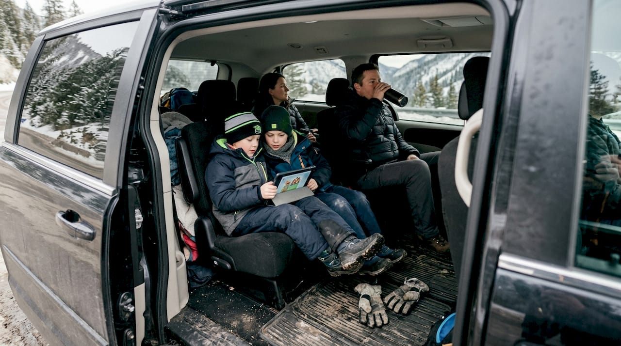 Family in comfy minivan on Alpine road
