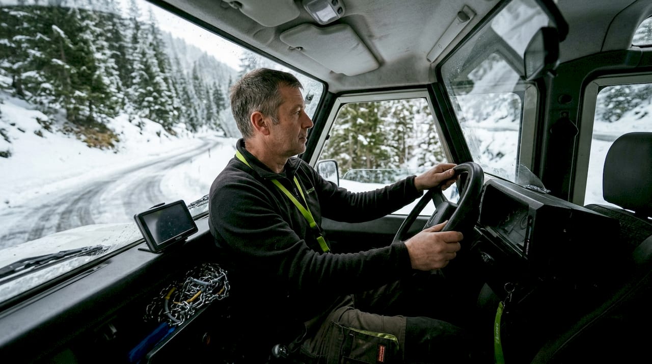 Skats no autobusa šofera vietas, vadot transfēru pa sniegotiem kalnu serpentīniem
