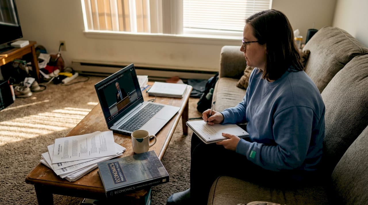 Woman taking notes during online degree course