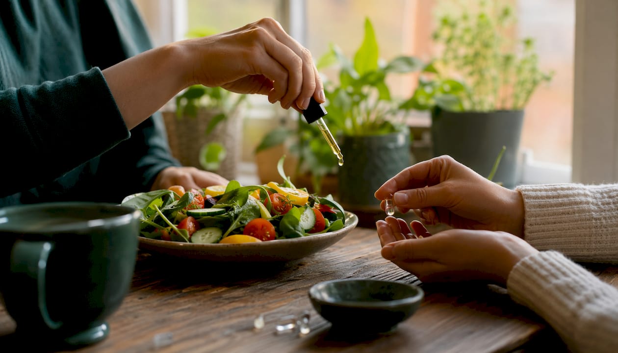 Detaljbild på händer som håller i veganska kapslar och olja