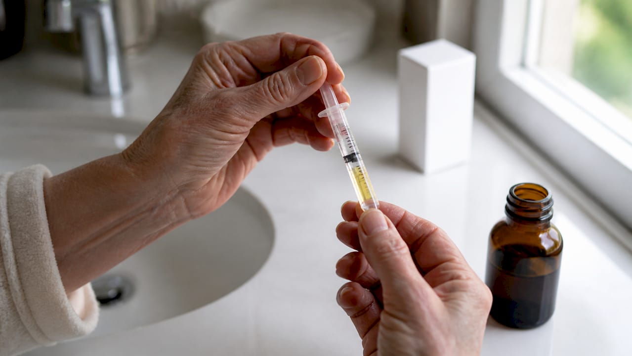 Hænder, der afmåler en dosis flydende medicin