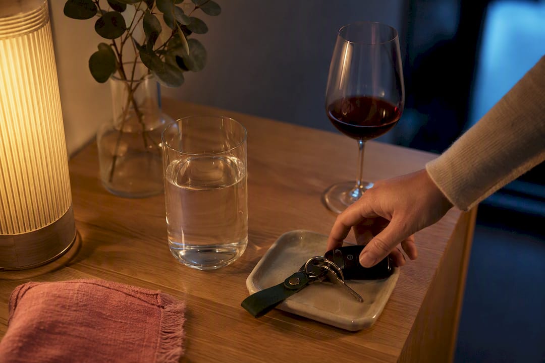 Vand, vinglas og bilnøgler ved siden af sengen
