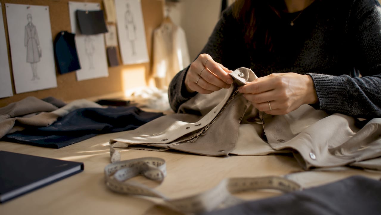 Hände passen die individuellen Elemente einer modularen Jacke an.