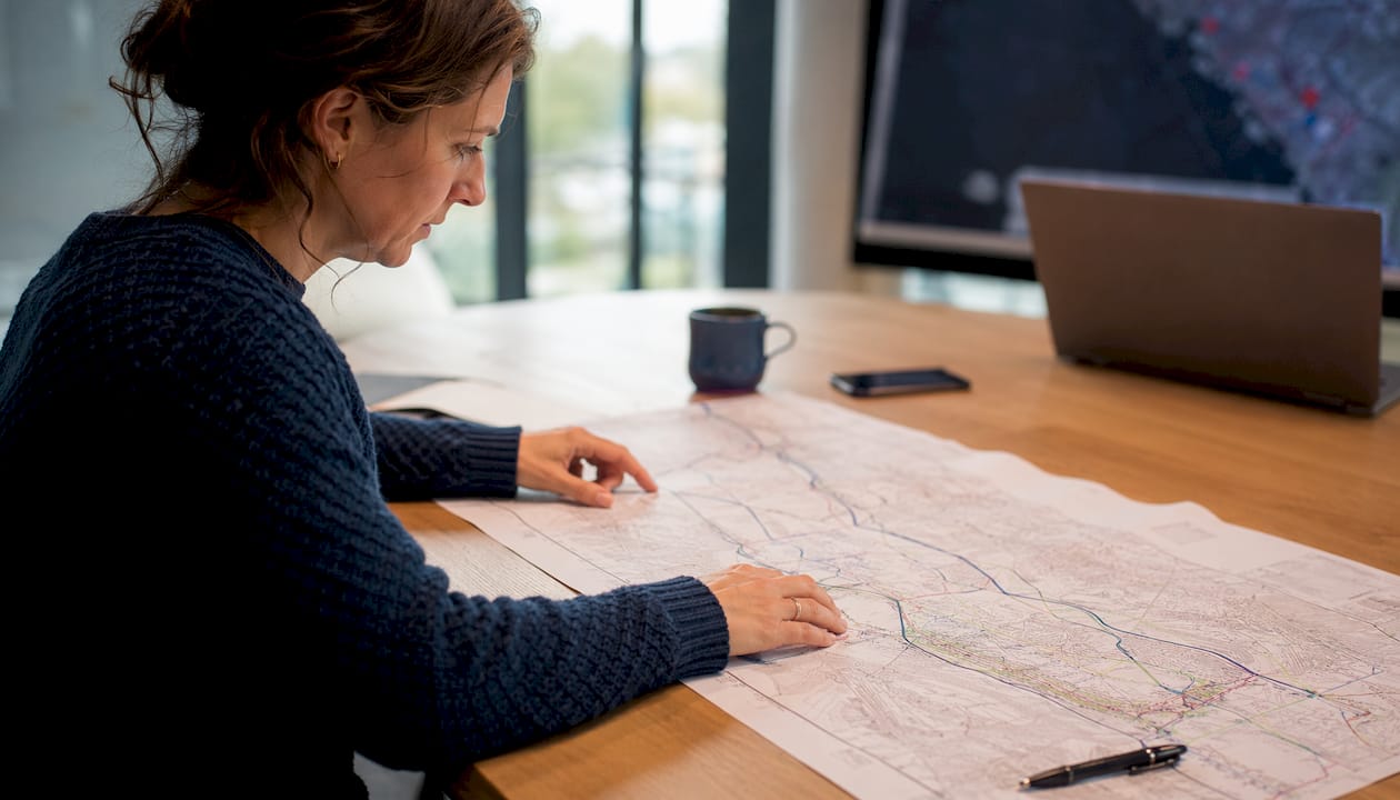 Eine Person untersucht eine GIS-Karte und führt eine Analyse durch.