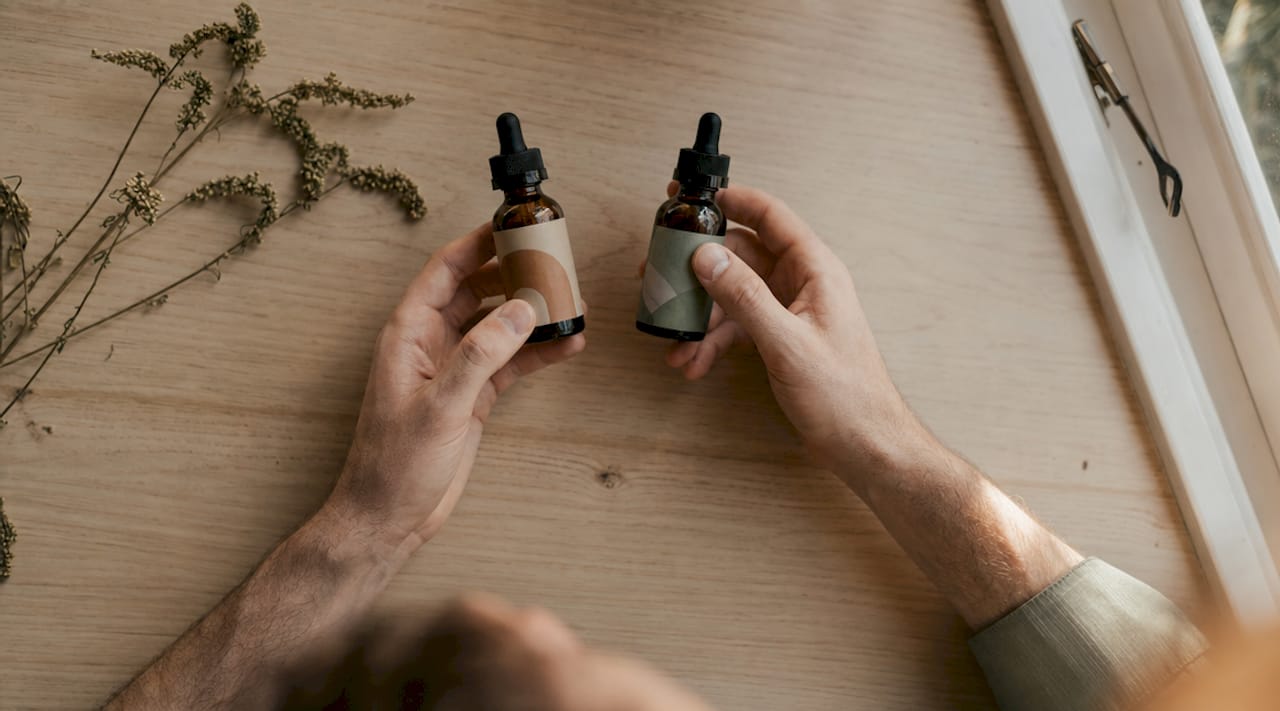 Des mains qui examinent et comparent différentes huiles de CBD