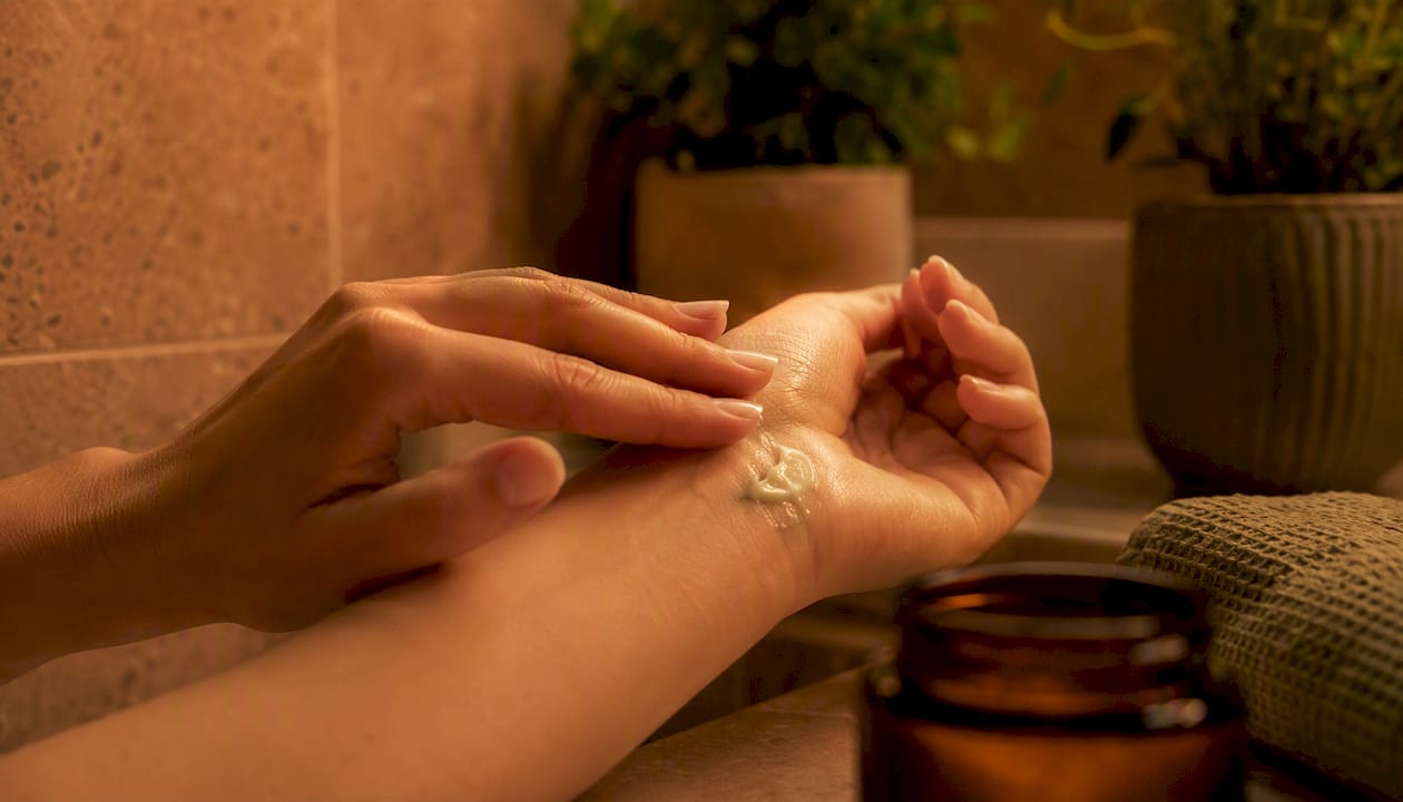 Application of CBD balm to skin with hands