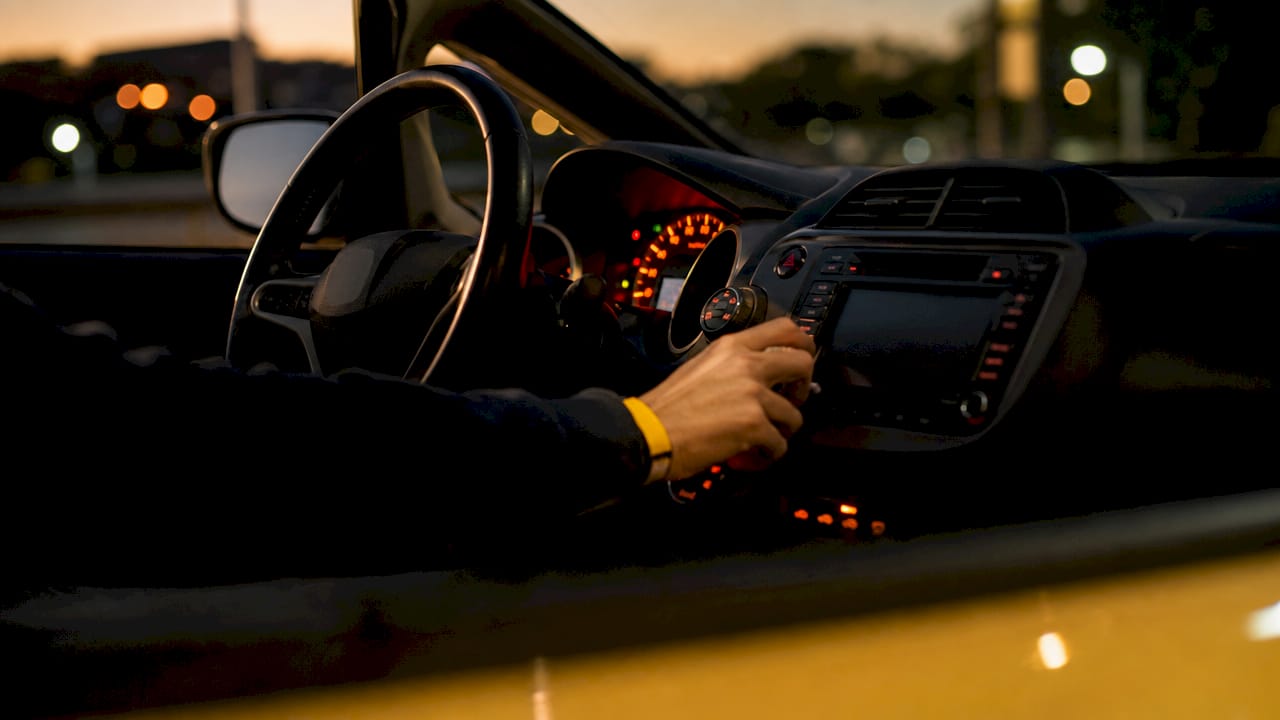 Driver adjusting car dashboard controls close-up