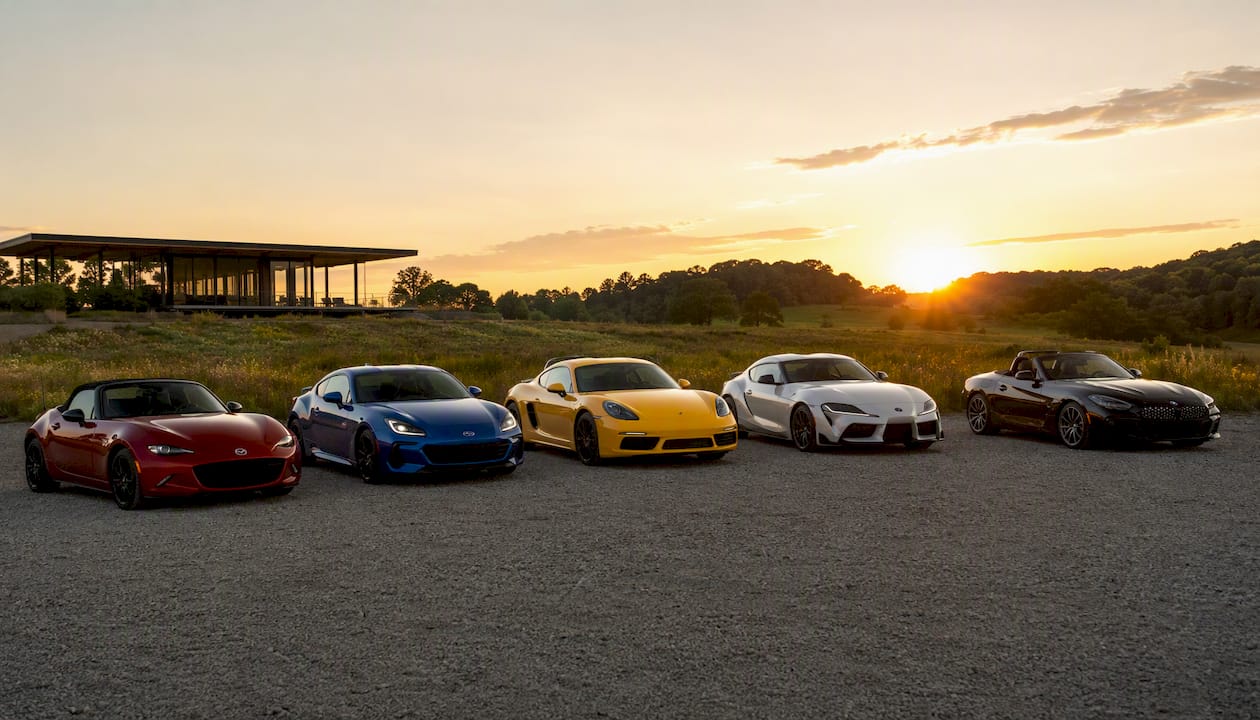 Lineup of lightweight sports cars outdoors in sunlight