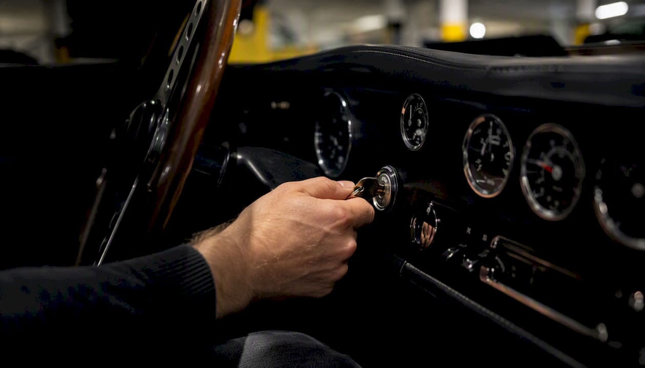 Hand inserting key into sports car ignition
